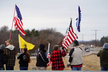 Oakdale, Wisconsin ABD - 4 Mart 2022: Pro Amerikalılar ve Trump taraftarları, I90 ve I94 otobanlarında Özgürlük Konvoyuna destek veren bayraklar sallayarak toplandılar.