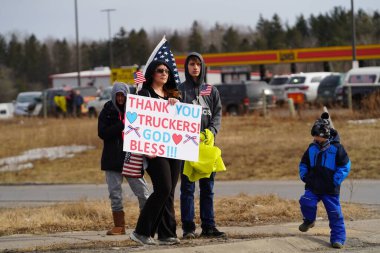 Oakdale, Wisconsin ABD - 4 Mart 2022: Pro Amerikalılar ve Trump taraftarları, I90 ve I94 otobanlarında Özgürlük Konvoyuna destek veren bayraklar sallayarak toplandılar.