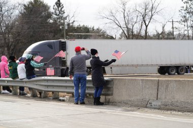 Oakdale, Wisconsin ABD - 4 Mart 2022: Pro Amerikalılar ve Trump taraftarları, I90 ve I94 otobanlarında Özgürlük Konvoyuna destek veren bayraklar sallayarak toplandılar.