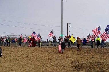 Oakdale, Wisconsin ABD - 4 Mart 2022: Pro Amerikalılar ve Trump taraftarları, I90 ve I94 otobanlarında Özgürlük Konvoyuna destek veren bayraklar sallayarak toplandılar.