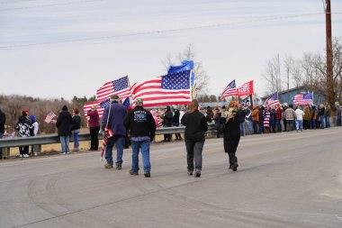 Oakdale, Wisconsin ABD - 4 Mart 2022: Pro Amerikalılar ve Trump taraftarları, I90 ve I94 otobanlarında Özgürlük Konvoyuna destek veren bayraklar sallayarak toplandılar.