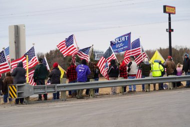 Oakdale, Wisconsin ABD - 4 Mart 2022: Pro Amerikalılar ve Trump taraftarları, I90 ve I94 otobanlarında Özgürlük Konvoyuna destek veren bayraklar sallayarak toplandılar.