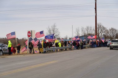 Oakdale, Wisconsin ABD - 4 Mart 2022: Pro Amerikalılar ve Trump taraftarları, I90 ve I94 otobanlarında Özgürlük Konvoyuna destek veren bayraklar sallayarak toplandılar.