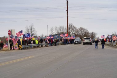 Oakdale, Wisconsin ABD - 4 Mart 2022: Pro Amerikalılar ve Trump taraftarları, I90 ve I94 otobanlarında Özgürlük Konvoyuna destek veren bayraklar sallayarak toplandılar.