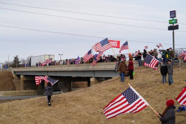 Oakdale, Wisconsin ABD - 4 Mart 2022: Pro Amerikalılar ve Trump taraftarları, I90 ve I94 otobanlarında Özgürlük Konvoyuna destek veren bayraklar sallayarak toplandılar.