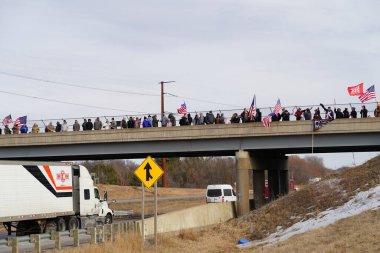 Oakdale, Wisconsin ABD - 4 Mart 2022: Pro Amerikalılar ve Trump taraftarları, I90 ve I94 otobanlarında Özgürlük Konvoyuna destek veren bayraklar sallayarak toplandılar.
