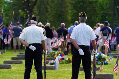 Marshfield, Wisconsin ABD - 29 Mayıs 2023: Erkek ve kadın gaziler, Anma Günü sırasında ölen askerlerin mezarlarını selamladılar.