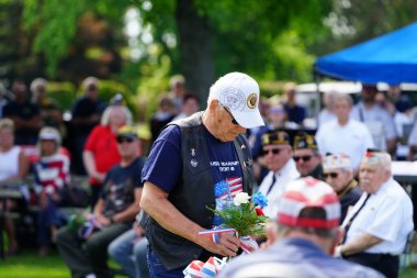 Marshfield, Wisconsin ABD - 29 Mayıs 2023: Erkek ve kadın gaziler, Anma Günü sırasında ölen askerlerin mezarlarını selamladılar.