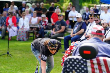 Marshfield, Wisconsin ABD - 29 Mayıs 2023: Erkek ve kadın gaziler, Anma Günü sırasında ölen askerlerin mezarlarını selamladılar.