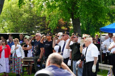 Marshfield, Wisconsin ABD - 29 Mayıs 2023: Erkek ve kadın gaziler, Anma Günü sırasında ölen askerlerin mezarlarını selamladılar.