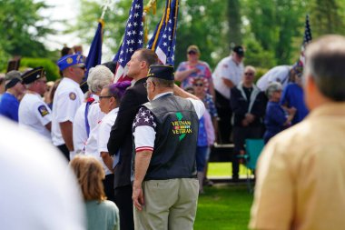 Marshfield, Wisconsin ABD - 29 Mayıs 2023: Erkek ve kadın gaziler, Anma Günü sırasında ölen askerlerin mezarlarını selamladılar.