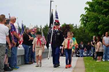 Neillsville, Wisconsin - 29 Mayıs 2023: Erkek ve kız izciler Amerikan bayrağını selamlamak için Ulusal Muhafız askerleriyle yürüdüler.