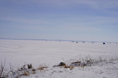 Green Lake, Wisconsin USA - 11 Şubat 2023: Buz tutmuş gölde buzda balık tutan insanlar.