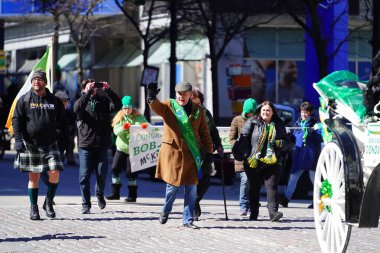 Milwaukee, Wisconsin ABD - 12 Mart 2022: Shamrock kulübü üyeleri Aziz Patrick günü için giyindiler ve geçit töreni için pankart taşıdılar
