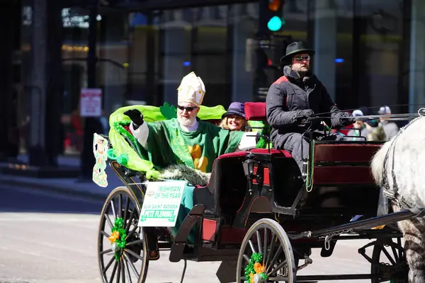 Milwaukee, Wisconsin ABD - 12 Mart 2022 Saint Patrick gibi giyinmiş bir adam Aziz Patrick Günü geçit töreninde el salladı..