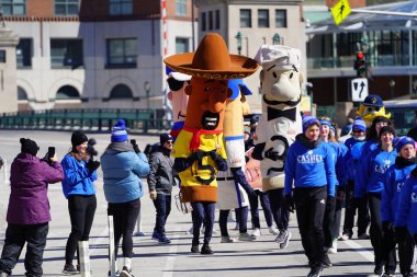 Milwaukee, Wisconsin ABD - 12 Mart 2022 Milwaukee Brewers Sosis maskotu yarışçıları St. Patrick Günü geçit töreninde yürüdüler