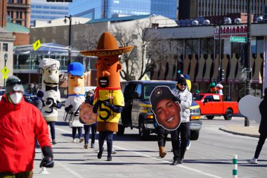 Milwaukee, Wisconsin ABD - 12 Mart 2022 Milwaukee Brewers Sosis maskotu yarışçıları St. Patrick Günü geçit töreninde yürüdüler.