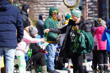 Milwaukee, Wisconsin ABD - 12 Mart 2022 Seyirciler 2022 St. Patrick Günü yürüyüşünü kaldırımlardan izledi.
