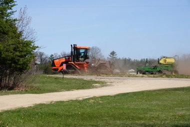 Yeni Lizbon, Wisconsin ABD - 5 Mayıs 2023: Orange Case IH Steiger 380 DS Quadtrac traktörü ekin tarlasında tarım