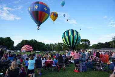 Seymour, Wisconsin ABD - 9 Ağustos 2019: Burger Festivali 'nde ziyaretçiler ve izleyiciler halk parkındaki hava balonu mitingini izliyorlar.