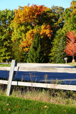 Wisconsin, Fond du Lac 'ta sonbahar mevsimi boyunca sonbahar renkli ormanların önünde tahta çitler bulunur.