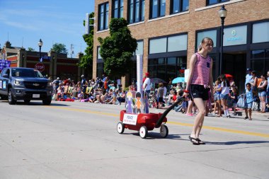 Sheboygan, Wisconsin ABD - 4 Temmuz 2019: Beytüllahim kilisesi ve yetişkin okulları ve Amerikan özgürlük renkleri giymiş çocuklar geçit töreninde izleyicilere şeker dağıtıyor