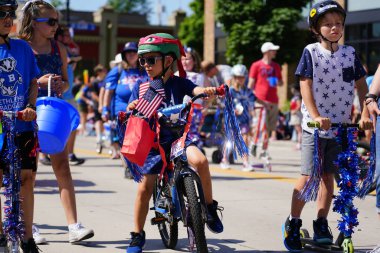 Sheboygan, Wisconsin ABD - 4 Temmuz 2019: Beytüllahim kilisesi ve yetişkin okulları ve Amerikan özgürlük renkleri giymiş çocuklar geçit töreninde izleyicilere şeker dağıtıyor