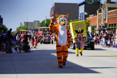 Sheboygan, Wisconsin ABD - 4 Temmuz 2019: Beytüllahim kilisesi ve yetişkin okulları ve Amerikan özgürlük renkleri giymiş çocuklar geçit töreninde izleyicilere şeker dağıtıyor
