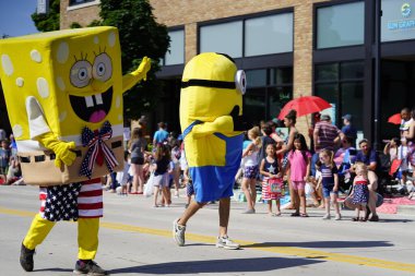 Sheboygan, Wisconsin ABD - 4 Temmuz 2019: Beytüllahim kilisesi ve yetişkin okulları ve Amerikan özgürlük renkleri giymiş çocuklar geçit töreninde izleyicilere şeker dağıtıyor