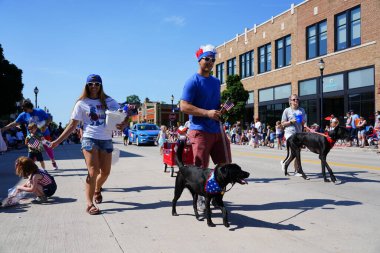 Sheboygan, Wisconsin ABD - 4 Temmuz 2019: Beytüllahim kilisesi ve yetişkin okulları ve Amerikan özgürlük renkleri giymiş çocuklar geçit töreninde izleyicilere şeker dağıtıyor