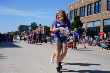 Sheboygan, Wisconsin ABD - 4 Temmuz 2019: Beytüllahim kilisesi ve yetişkin okulları ve Amerikan özgürlük renkleri giymiş çocuklar geçit töreninde izleyicilere şeker dağıtıyor