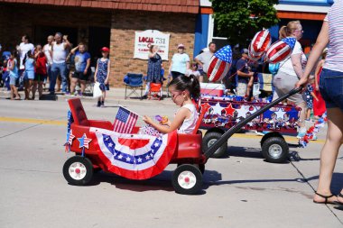 Sheboygan, Wisconsin ABD - 4 Temmuz 2019: Beytüllahim kilisesi ve yetişkin okulları ve Amerikan özgürlük renkleri giymiş çocuklar geçit töreninde izleyicilere şeker dağıtıyor.