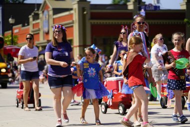 Sheboygan, Wisconsin ABD - 4 Temmuz 2019: Beytüllahim kilisesi ve yetişkin okulları ve Amerikan özgürlük renkleri giymiş çocuklar geçit töreninde izleyicilere şeker dağıtıyor
