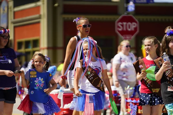 Sheboygan, Wisconsin ABD - 4 Temmuz 2019: Beytüllahim kilisesi ve yetişkin okulları ve Amerikan özgürlük renkleri giymiş çocuklar geçit töreninde izleyicilere şeker dağıtıyor
