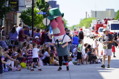 Sheboygan, Wisconsin ABD - 4 Temmuz 2019 Johnsonville sosis maskotu özgürlük yürüyüşünde yürüdü ve sokak kenarındaki çocukları selamladı..