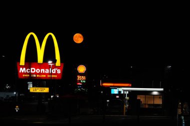 Ripon, Wisconsin ABD 'yi deldi - 4 Ağustos 2023: Turuncu süper ay gece boyunca McDonald' s restoranının önünde asıldı..