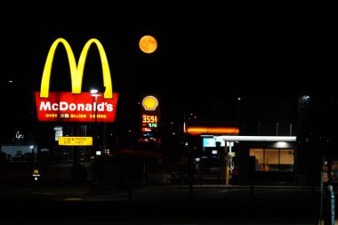 Ripon, Wisconsin ABD 'yi deldi - 4 Ağustos 2023: Turuncu süper ay gece boyunca McDonald' s restoranının önünde asıldı..