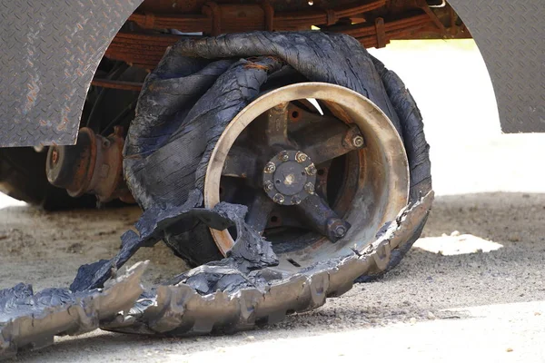 A blown truck tire sits on the roadside.