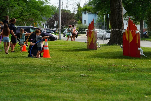 Fond du Lac, Wisconsin ABD - 1 Ağustos 2023: Yerel Polis, Şerif ve itfaiyeci memurlar, Ulusal Gece Gezisi Aile Eğlencesi etkinliği için cemaat aileleriyle bir araya geldi