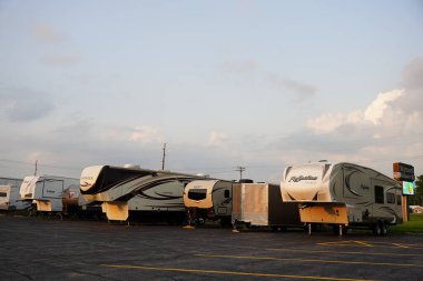 Tomah, Wisconsin ABD - 10 Ağustos 2021: Farklı marka karavan karavanları depolama için bir otoparkta oturuyorlar.