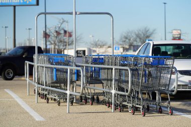 Fond du Lac, Wisconsin USA - 26 Kasım 2022 Walmart otoparkındaki bir alışveriş arabasında oturan mavi ve gri alışveriş arabaları.