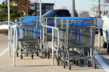 Fond du Lac, Wisconsin USA - 26 Kasım 2022 Walmart otoparkındaki bir alışveriş arabasında oturan mavi ve gri alışveriş arabaları.