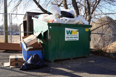 Mauston, Wisconsin ABD - 23 Kasım 2020: Atık yönetimi yeşil çöp bidonları toplum için kullanılmak üzere dışarıda duruyor   