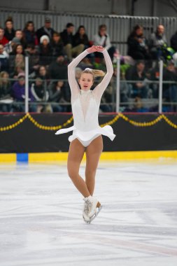 Mosinee, Wisconsin ABD - 26 Şubat 2021: Porsuk Eyaleti buz pateni yarışmasına beyaz elbiseli genç bir kadın katıldı.