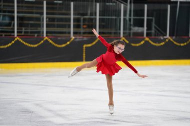 Mosinee, Wisconsin ABD - 26 Şubat 2021: Porsuk Eyaleti buz pateni yarışmasına güzel kırmızı elbiseli yetişkin kadın katıldı