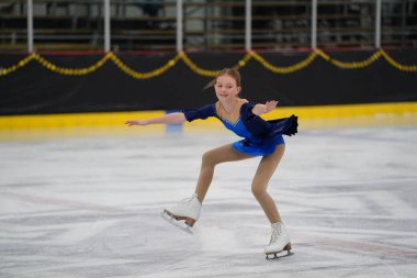 Mosinee, Wisconsin ABD - 26 Şubat 2021: Güzel mavi elbiseli genç Asyalı kadın porsuk eyaleti buz pateni yarışmasına katıldı
