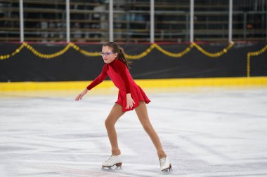 Mosinee, Wisconsin ABD - 26 Şubat 2021: Porsuk Eyaleti buz pateni yarışmasına katılan kırmızı elbiseli genç bir kadın.