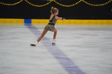 Mosinee, Wisconsin ABD - 26 Şubat 2021: Porsuk eyaleti buz pateni yarışmasına katılan güzel renkli elbiseli genç bir kadın