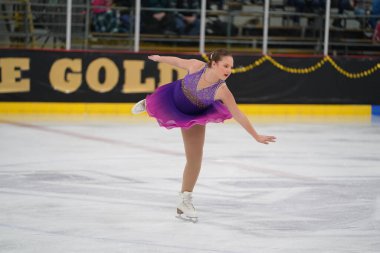Mosinee, Wisconsin ABD - 26 Şubat 2021: Porsuk eyaleti buz pateni yarışmasına katılan güzel renkli elbiseli genç bir kadın