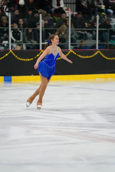 米国ウィスコンシン州モシニア 2021年2月26日 美しい青いドレスの若い成人女性がより悪い州の冬のゲームアイススケート競技に参加しました — ストック写真